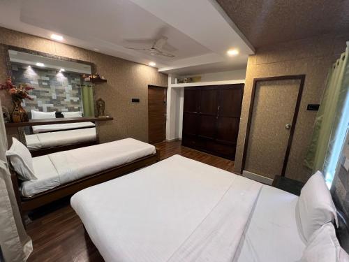 a room with two beds and a mirror at Vishranthi Home Stay in Chennai