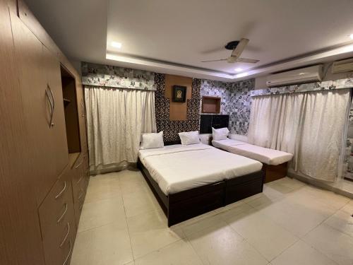 a bedroom with two beds in a room at Vishranthi Home Stay in Chennai