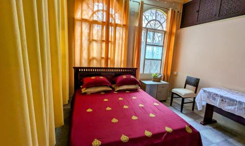 a bedroom with a red bed with red sheets and pillows at Saikia Nest the 'Class-Apart' Apartments, each with 2 Bedrooms, 2 full Bathrooms, Living & Dinning room, Modular Kitchen, Balcony or Veranda in Guwahati