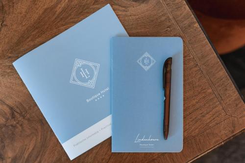 een pen bovenop een blauwe envelop bij De Lindenhoeve Boutique Hotel in Sluis