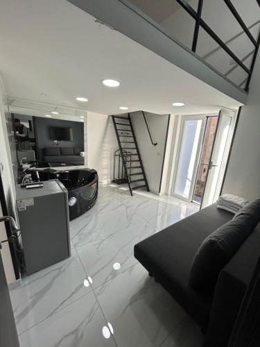 a living room with a black couch and a kitchen at LUIGI LUXURY SUITE in Naples