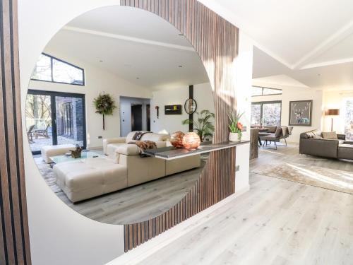 a living room with a large round mirror on the wall at Heilan Roo in Pitlochry