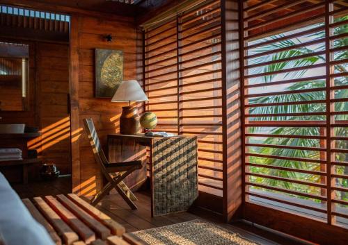 a room with a desk with a lamp and a chair at Cabo Serai in Canacona