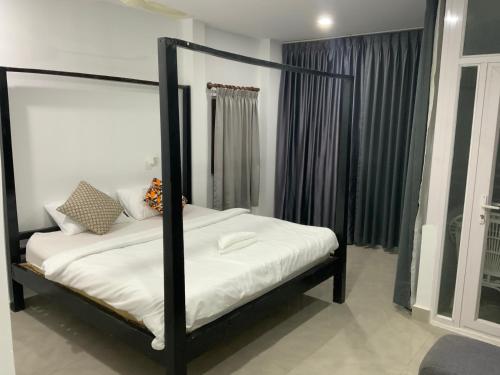 Julieka’s Guesthouse في بنوم بنه: سرير بإطار أسود في الغرفة
