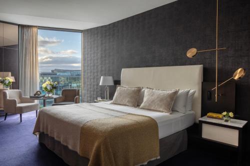 a bedroom with a large bed and a large window at Anantara The Marker Dublin- A Leading Hotel of the World in Dublin