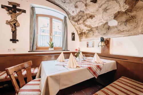 Gasthof Greimel في لاوفن: غرفة طعام مع طاولة و صليب على الحائط