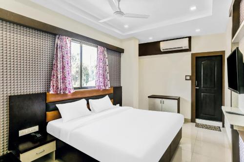 um quarto com uma grande cama branca e uma janela em Hotel Geeta Palace em Mumbai