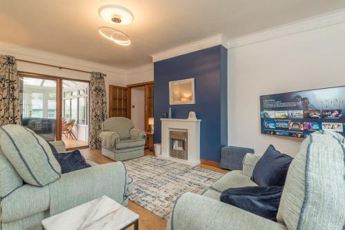 a living room with two chairs and a fireplace at Creigia-Betws in Betws-y-coed