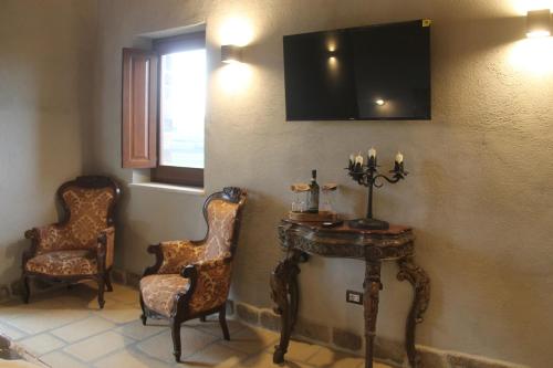 a room with two chairs and a table and a tv at Pietre di Fiume in Apice