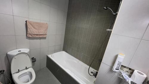 a bathroom with a toilet and a tub and a sink at Luxury Twin Room Ajman One Tower in Ajman 