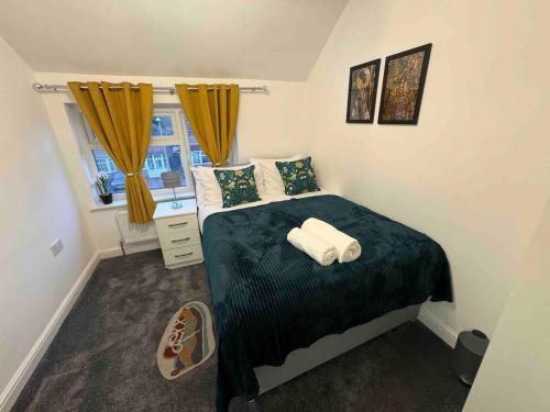 een slaapkamer met een bed met twee handdoeken erop bij The Ideal Beautiful 3-Bed House in Birmingham in Birmingham