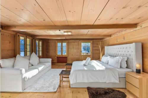 a large room with two beds and a couch at Mountain Chalet - Panoramic Terraces - Near Gstaad in Devant