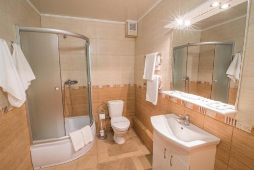 ein Bad mit einem WC, einem Waschbecken und einer Dusche in der Unterkunft Готель Україна in Lokhvytsya