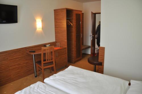 Schlafzimmer mit einem Bett, einem Tisch und einem Schreibtisch in der Unterkunft Gasthof zur Linde in Sankt Andrä bei Frauenkirchen