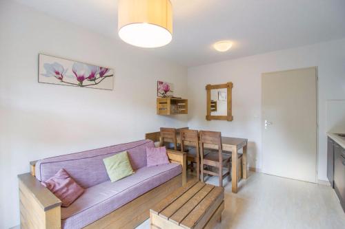 uma sala de estar com um sofá roxo e uma mesa em Les Terrasses du Lac J43 em Aureilhan