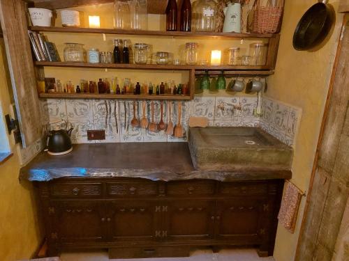 a kitchen with a sink and a shelf with utensils at A little bit of Magic - Witchcraft in York