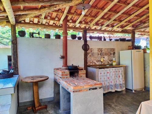 an outdoor kitchen with a stove and a refrigerator at Pousada Paineira in São Gonçalo do Rio das Pedras