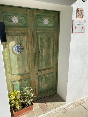 una gran puerta de madera en una habitación con plantas en Casa Giovannina, en Bernalda