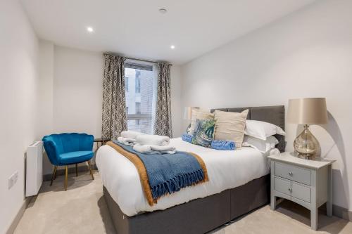 a bedroom with a large bed and a blue chair at Little Sea in Poole