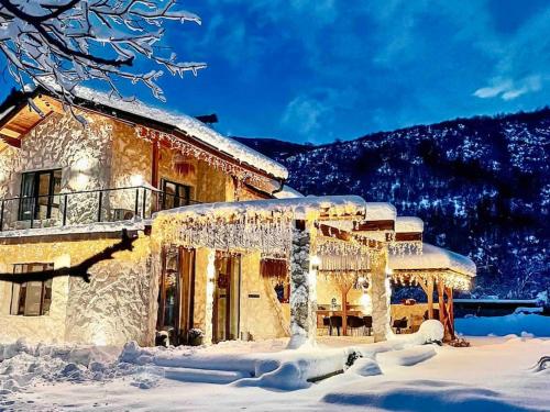 a house covered in snow with icicles on it at Valmont Luxury Chalet in Glozhene