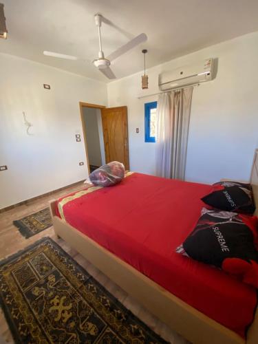een slaapkamer met een groot bed en een rode deken bij Capital of Sun in Luxor