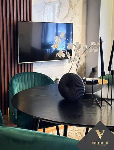a black table with a vase on top of it at Valmont Luxury Chalet in Glozhene
