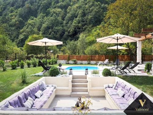 un patio trasero con sofás morados y una piscina en Valmont Luxury Chalet, 