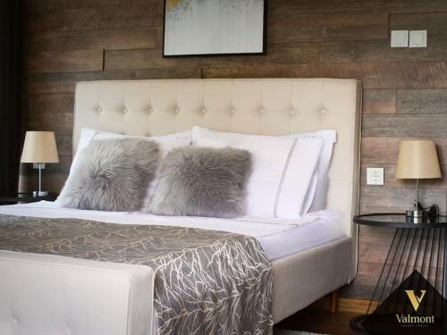 1 dormitorio con 1 cama blanca y 2 almohadas en Valmont Luxury Chalet, 