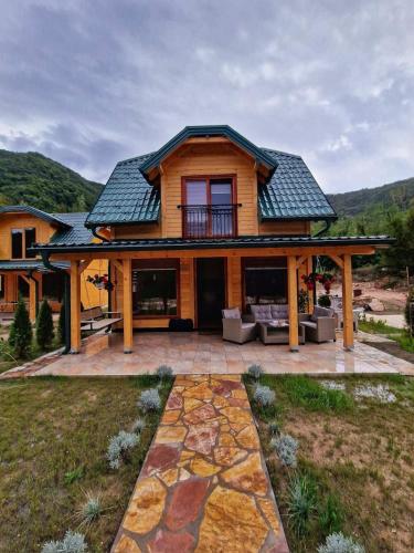 a log home with a patio and a roof at Stara pruga Jaz 2 in Višegrad