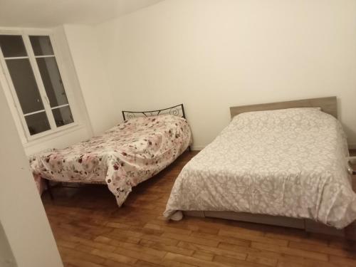 1 Schlafzimmer mit 2 Betten und einem Fenster in der Unterkunft Bel appartement lumineux avec terrasse proche centre ville et plages in Douarnenez