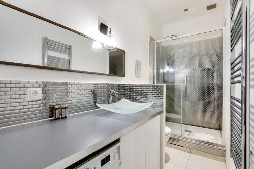 une salle de bain avec un lavabo, des toilettes et un miroir dans l'établissement Appart confortable -1BR 4P- Quartier Beaubourg, à Paris