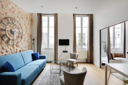 un salon avec un canapé bleu et des chaises dans l'établissement Appart confortable -1BR 4P- Quartier Beaubourg, à Paris
