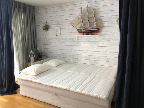 ein Schlafzimmer mit einem großen Bett mit einem Modellschiff an der Wand in der Unterkunft Beach Home, Köpingsvik in Köpingsvik