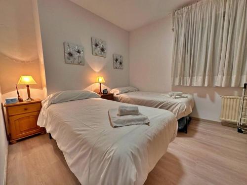 een slaapkamer met 2 bedden, 2 lampen en een raam bij Pics, centro de Andorra para 6. in Andorra la Vella