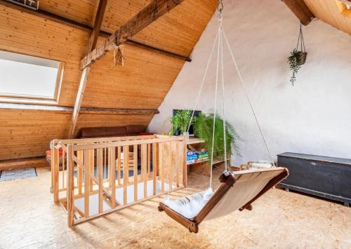 a swing in a room with a wooden ceiling at Vitaflow logies in Koksijde