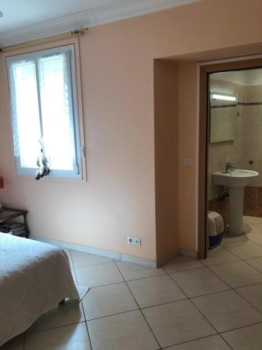 une chambre avec un lit, un lavabo et une fenêtre dans l'établissement Villa avec Jardin à 5 min de marche du centre de Cannes et plages, à Cannes