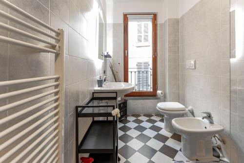 uma casa de banho com um lavatório, um WC e uma janela. em casa/studio Ricard Centro storico Arona em Arona