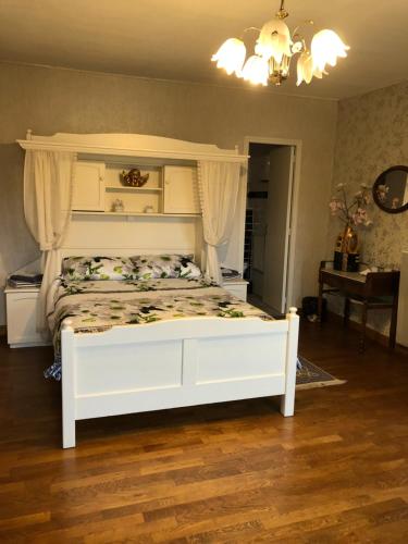 une chambre avec un lit blanc à baldaquin dans l'établissement Le Voyageur, à Saint-Bonnet-Tronçais