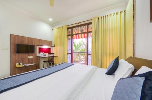 um quarto com uma grande cama branca e uma janela em Palm 34 em Jaipur