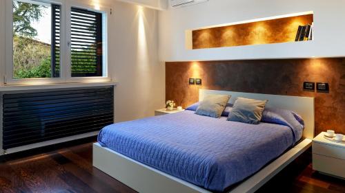 1 Schlafzimmer mit 1 Kingsize-Bett und 2 Fenstern in der Unterkunft VILLA VAE VICTIS 6, Emma Villas in Coriano