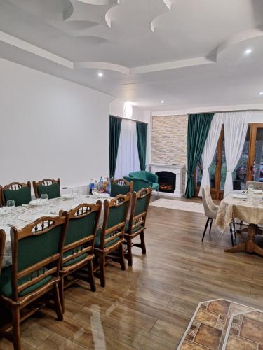 a dining room with a table and chairs and a fireplace at Pensiunea Casa Ancuta in Vadu Izei