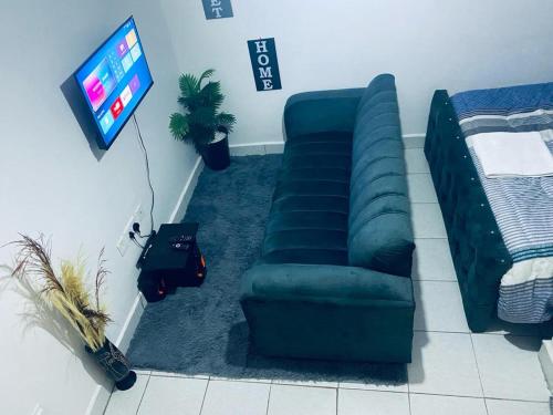 een woonkamer met een bank en een tv bij Providence suites in Nairobi