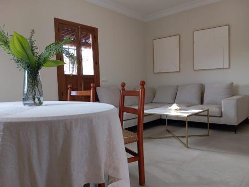 sala de estar con mesa y sofá en Villa Naranjo, en Sevilla
