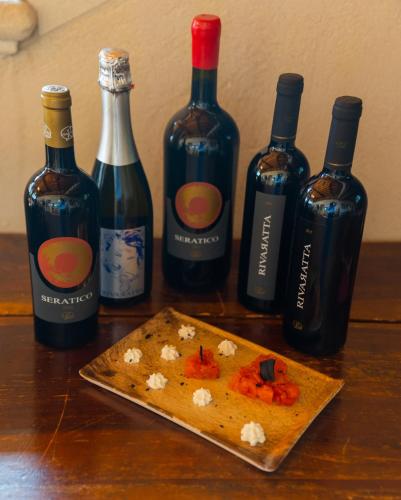 a group of bottles of wine and a cutting board at AGRITURISMO RIVA RATTA in Montecchio Maggiore