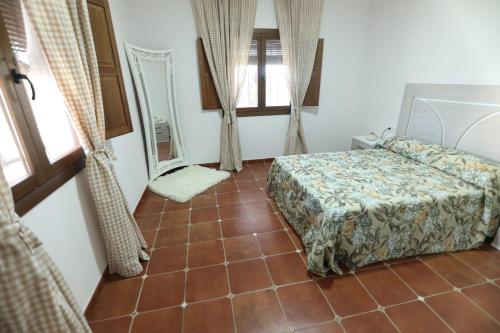 a bedroom with a bed and a tiled floor at Villa Romero in Mairena del Alcor