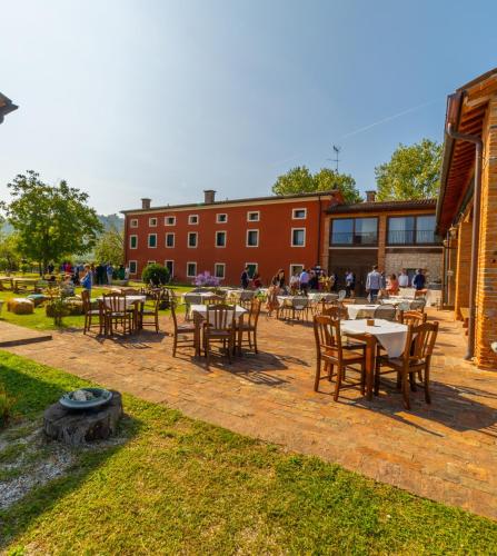 a patio with tables and chairs and a building at AGRITURISMO RIVA RATTA in Montecchio Maggiore