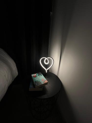 une table avec un livre et un éclairage cardiaque dans l'établissement Appart plein centre - Astoria, à Aix-les-Bains