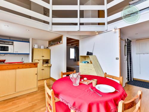 une cuisine et une table avec un tissu de table rouge dans l'établissement Vif océan, à Saint-Hilaire-de-Riez