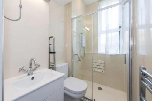 a bathroom with a toilet and a sink and a shower at Spare Room Stay in Edinburgh