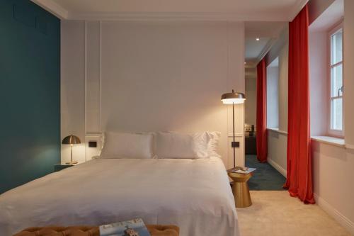 a bedroom with a large white bed with red curtains at The Townhouse in Udine